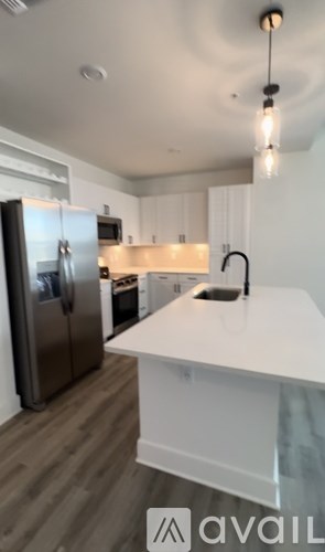 A kitchen with a white countertop and a stainless steel refrigerator.