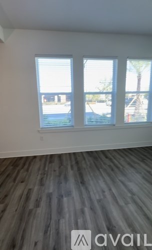 A room with a large window and wooden flooring.