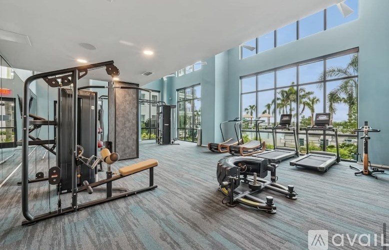 A gym with a variety of equipment including treadmills, weights, and exercise machines.