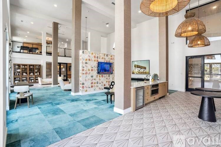 A spacious living room with a blue carpet and a television mounted on the wall.