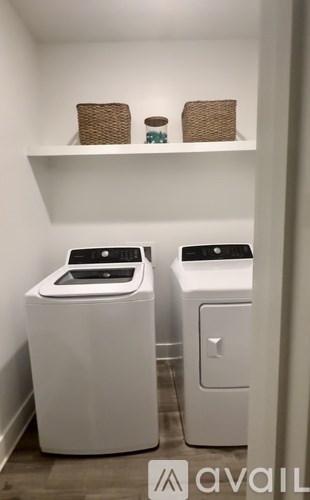 A white laundry room with a washer and dryer.