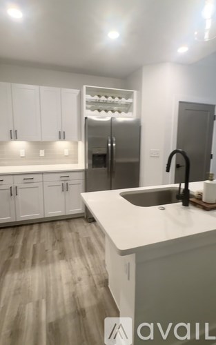 A kitchen with white cabinets and a white countertop.