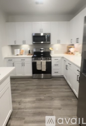 A kitchen with white cabinets and a black stove top oven.