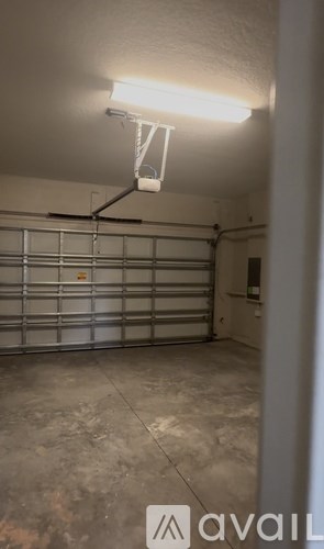 A garage with a wall-mounted light fixture and a closed metal garage door.