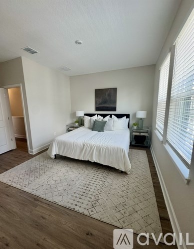 A bedroom with a large bed and a painting on the wall.