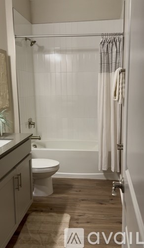 A bathroom with a toilet, a bathtub, and a shower curtain.