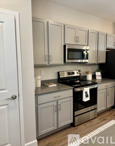 A kitchen with a white door and a stove with a pot on it.