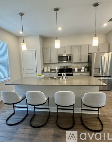 A modern kitchen with a center island and chairs.