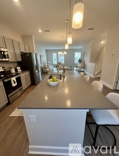 A kitchen with a bowl of fruit on the island.