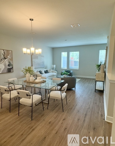 A modern living room with a glass table and white chairs.