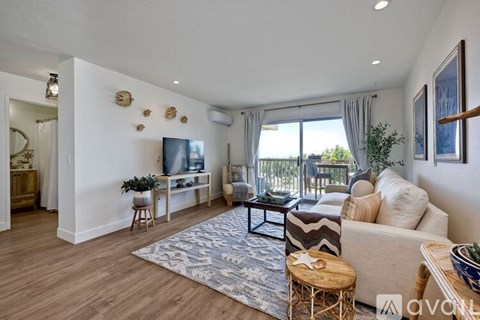 A living room with a white couch, a wooden coffee table, and a rug on the floor.