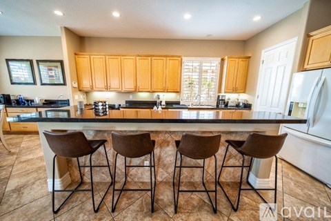 A kitchen with brown chairs and a countertop.