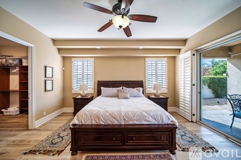 A bedroom with a large bed and a ceiling fan.