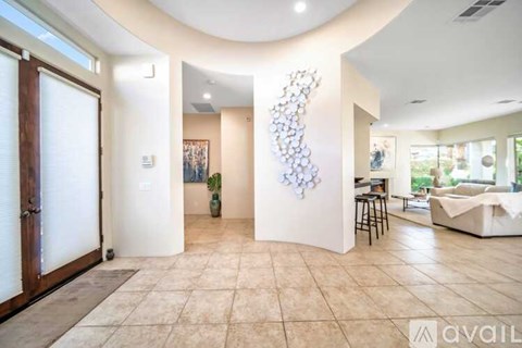 A modern living room with a large sculpture on the wall and a couch in the background.