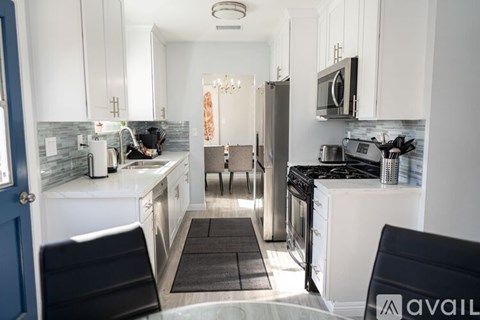 A kitchen with white cabinets and a black stove top oven.