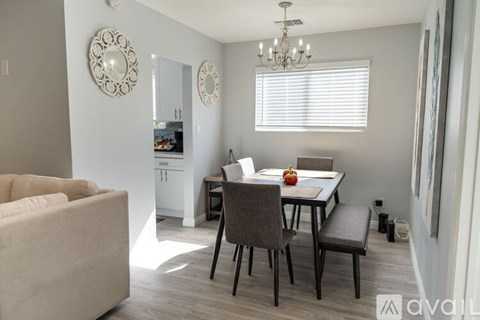 A dining room with a table, chairs, and a chandelier.