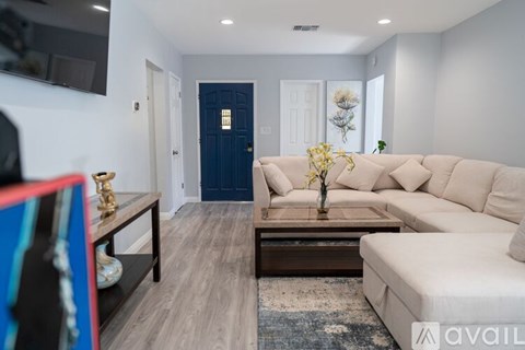 A living room with a white couch and a blue door.