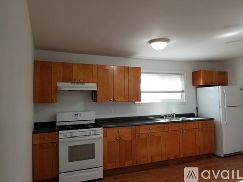 A kitchen with wooden cabinets and white appliances.