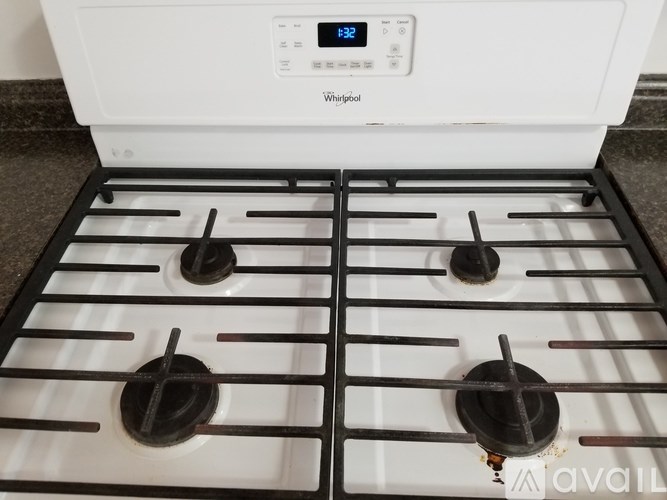A white Whirlpool stove top with four burners and a digital clock display.