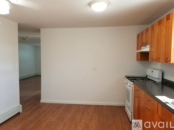 A kitchen with wooden cabinets and a white fridge.