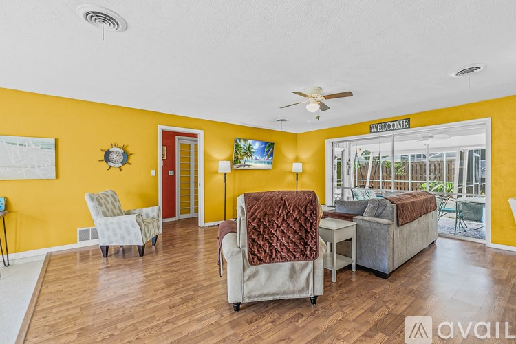 A living room with a yellow wall and furniture.