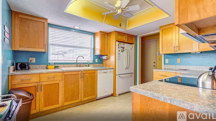 A kitchen with wooden cabinets and a white refrigerator.