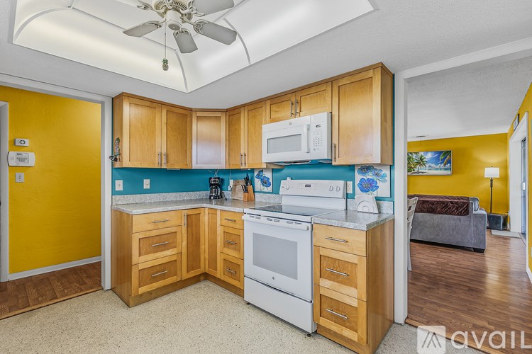 A kitchen with wooden cabinets and a white stove top oven.