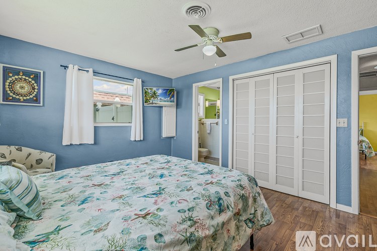 A bedroom with a bed, a ceiling fan, and a cabinet.