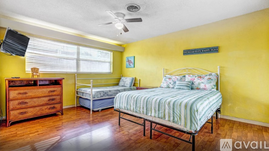 A bedroom with a bed, a dresser, and a window.