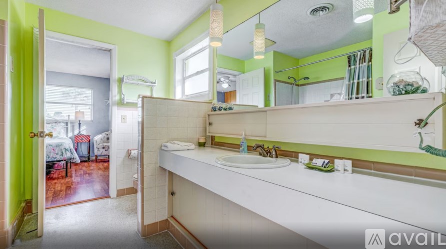 A bathroom with green walls and a white sink.