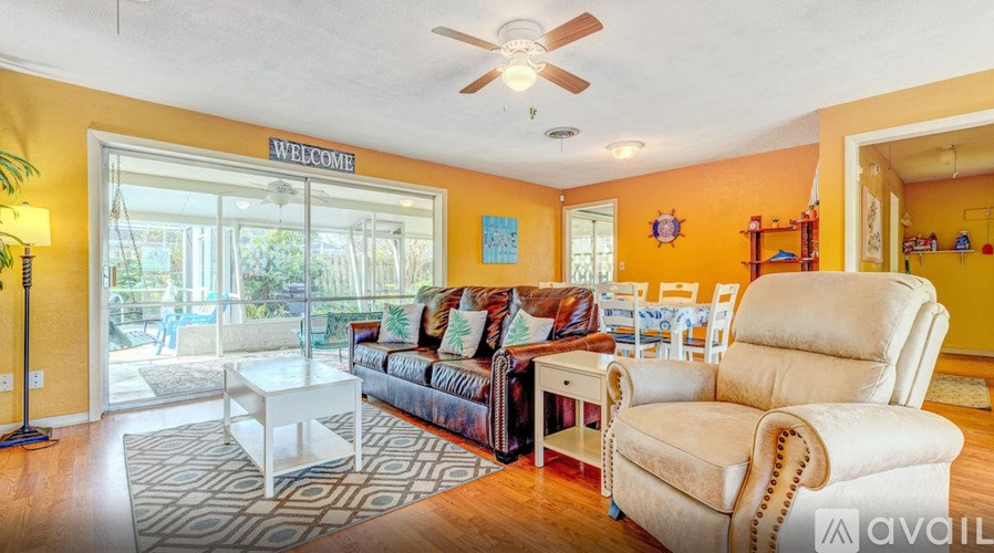 A living room with a sofa, chairs, and a rug.