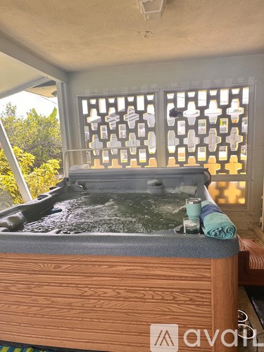 A hot tub with a towel and a candle on it.