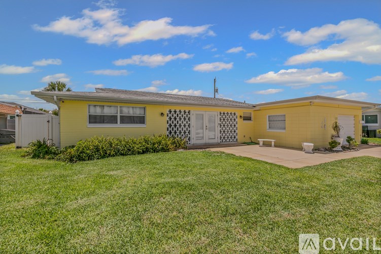 A living room with a white couch and a yellow wall.