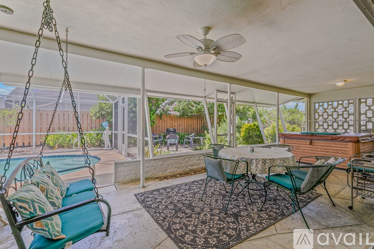 A patio with a table, chairs, and a swing.