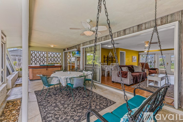 A patio with a table and chairs and a swing.