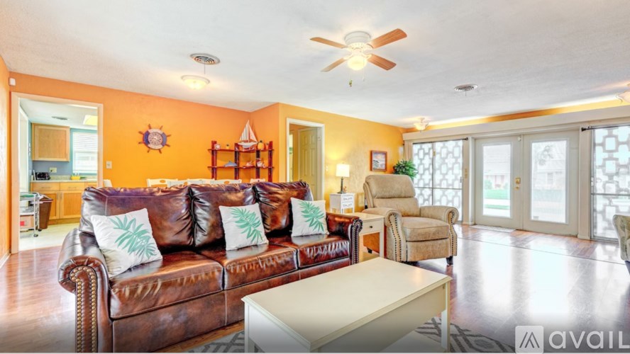 A living room with a brown leather couch and a white coffee table.