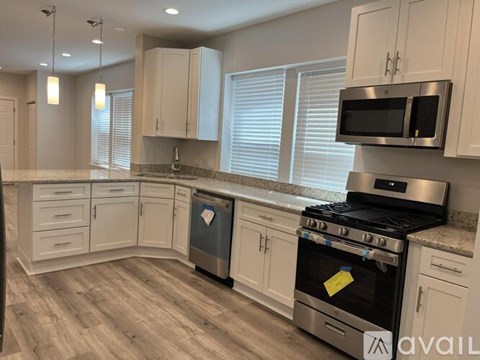 A kitchen with a black stove top oven and a black microwave above it.