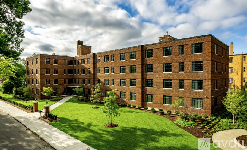 A large brick building with a green lawn in front.