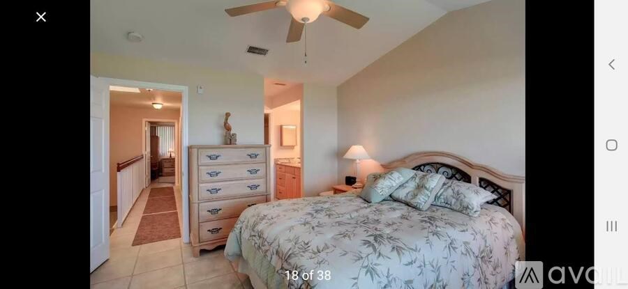 A bedroom with a large bed and a dresser with a mirror above it.