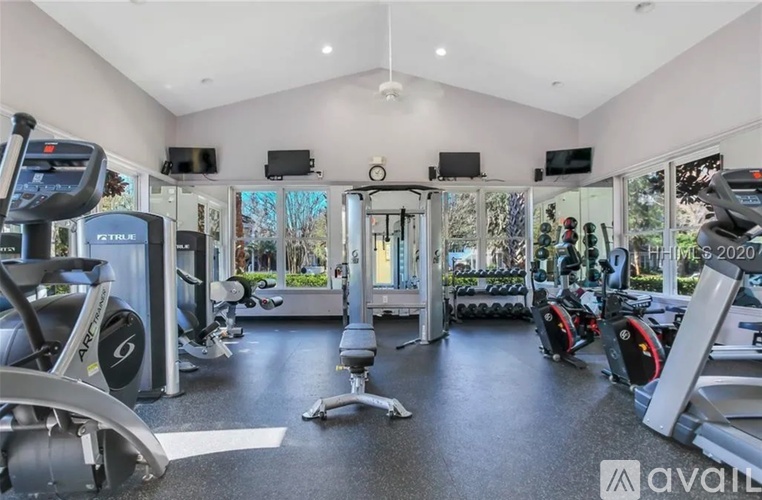 A gym with a variety of equipment including treadmills, weights, and exercise machines.