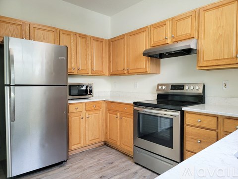A kitchen with wooden cabinets and stainless steel appliances.