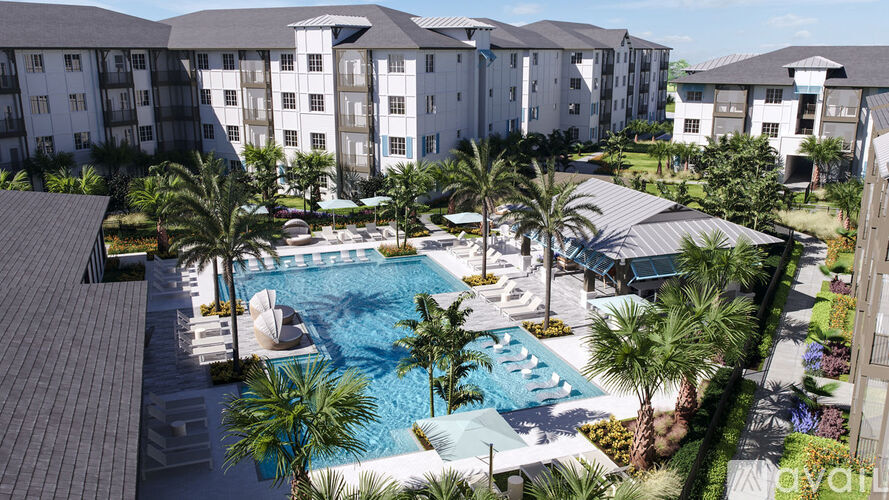 A large swimming pool surrounded by palm trees and buildings.