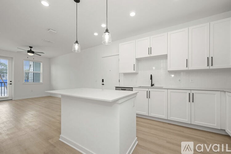 A spacious kitchen with white cabinets and a central island.