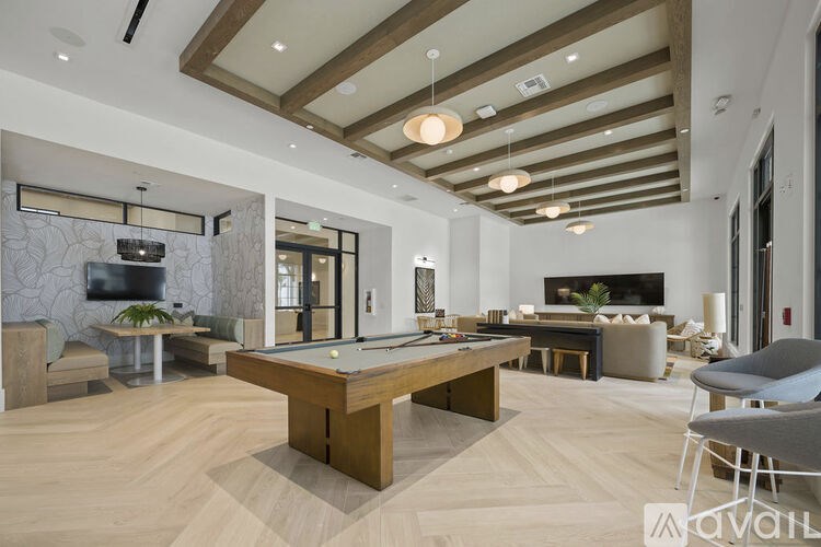 A spacious living room with a billiard table and a television.