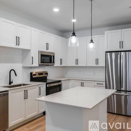 A kitchen with white cabinets and a white island.