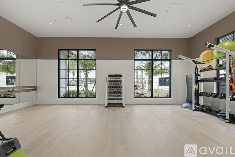A spacious room with a ceiling fan and a rack of dumbbells.