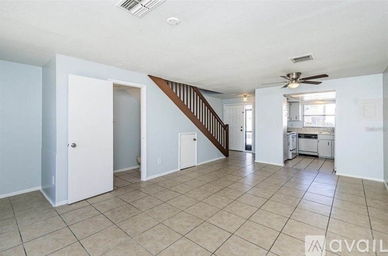A spacious living room with a staircase leading to the upper floor.