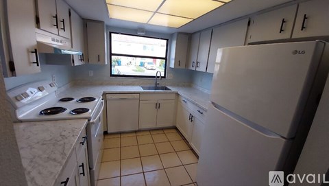 A kitchen with white appliances and cabinets.