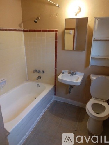 A bathroom with a tub, toilet, and sink.
