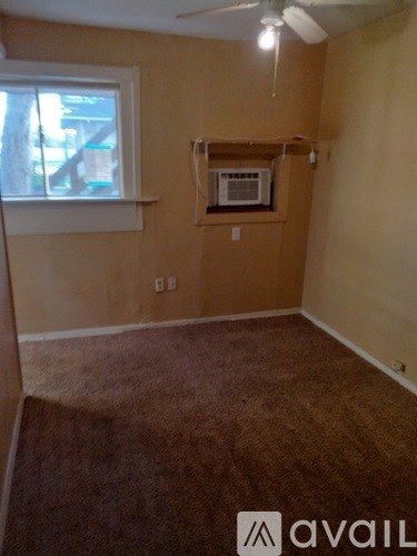 A room with a window and a fan on the ceiling.